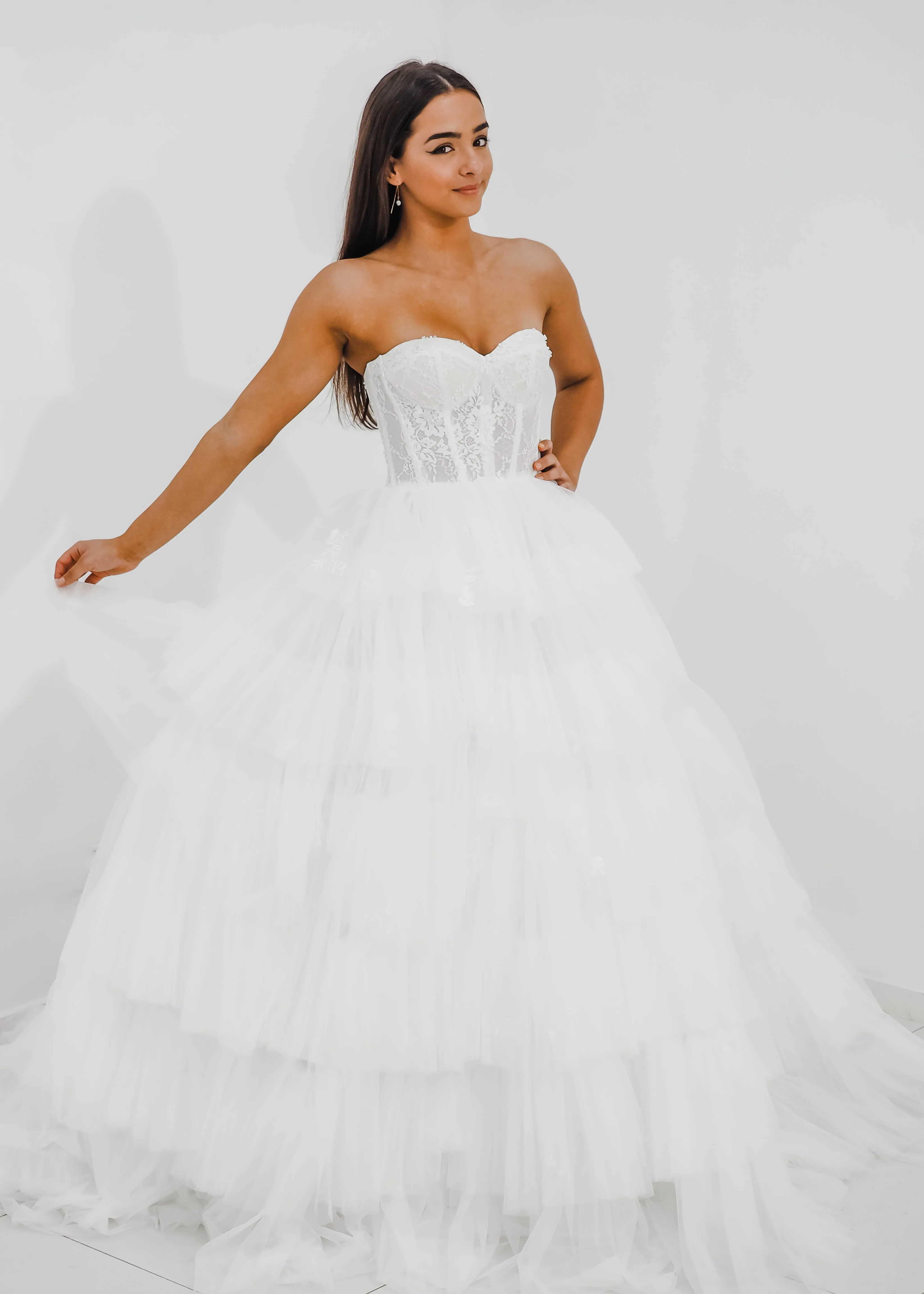 White wedding dress with a bushier top and a bushier puffy layered skirt
