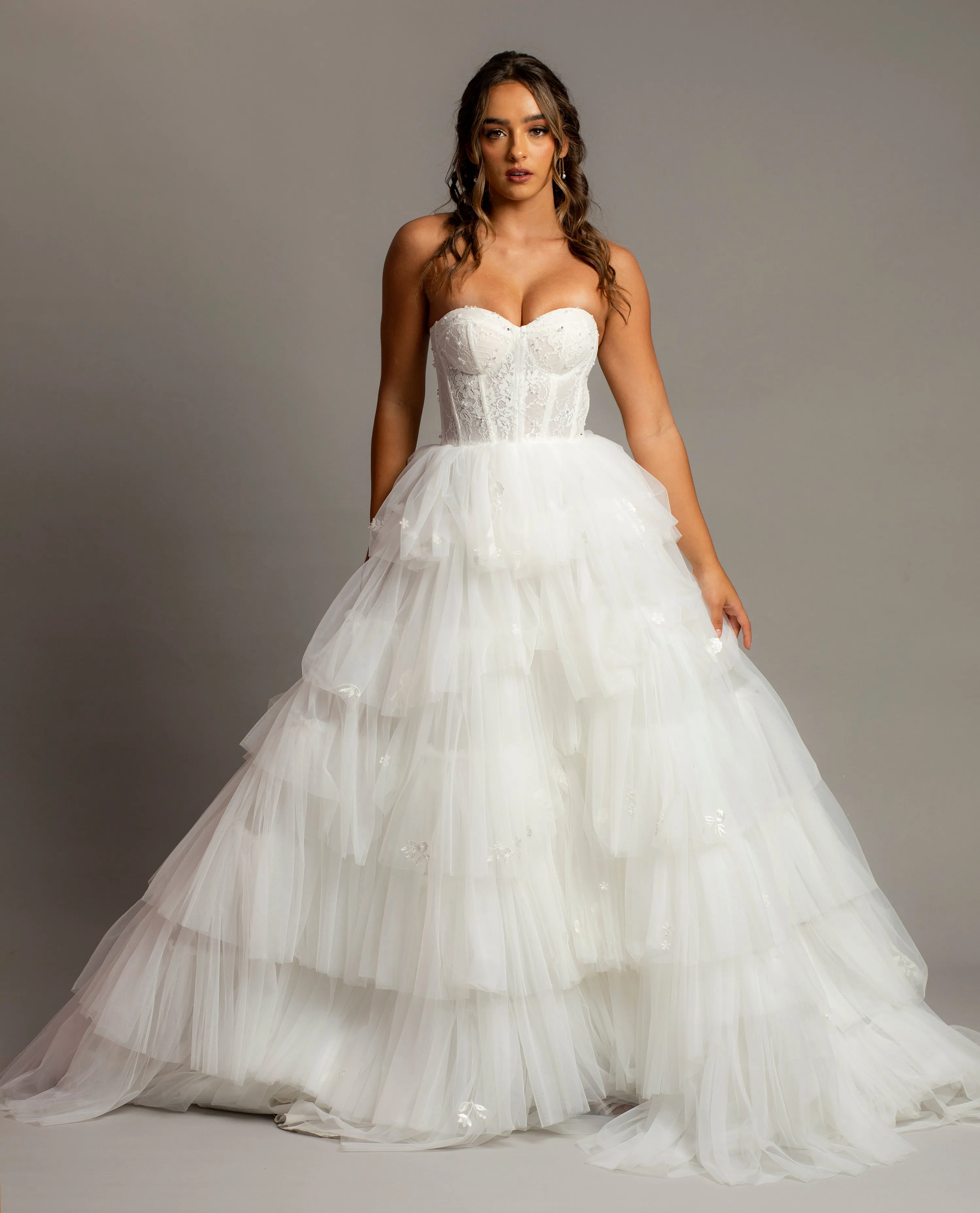 White wedding dress with a bushier top and a bushier puffy layered skirt
