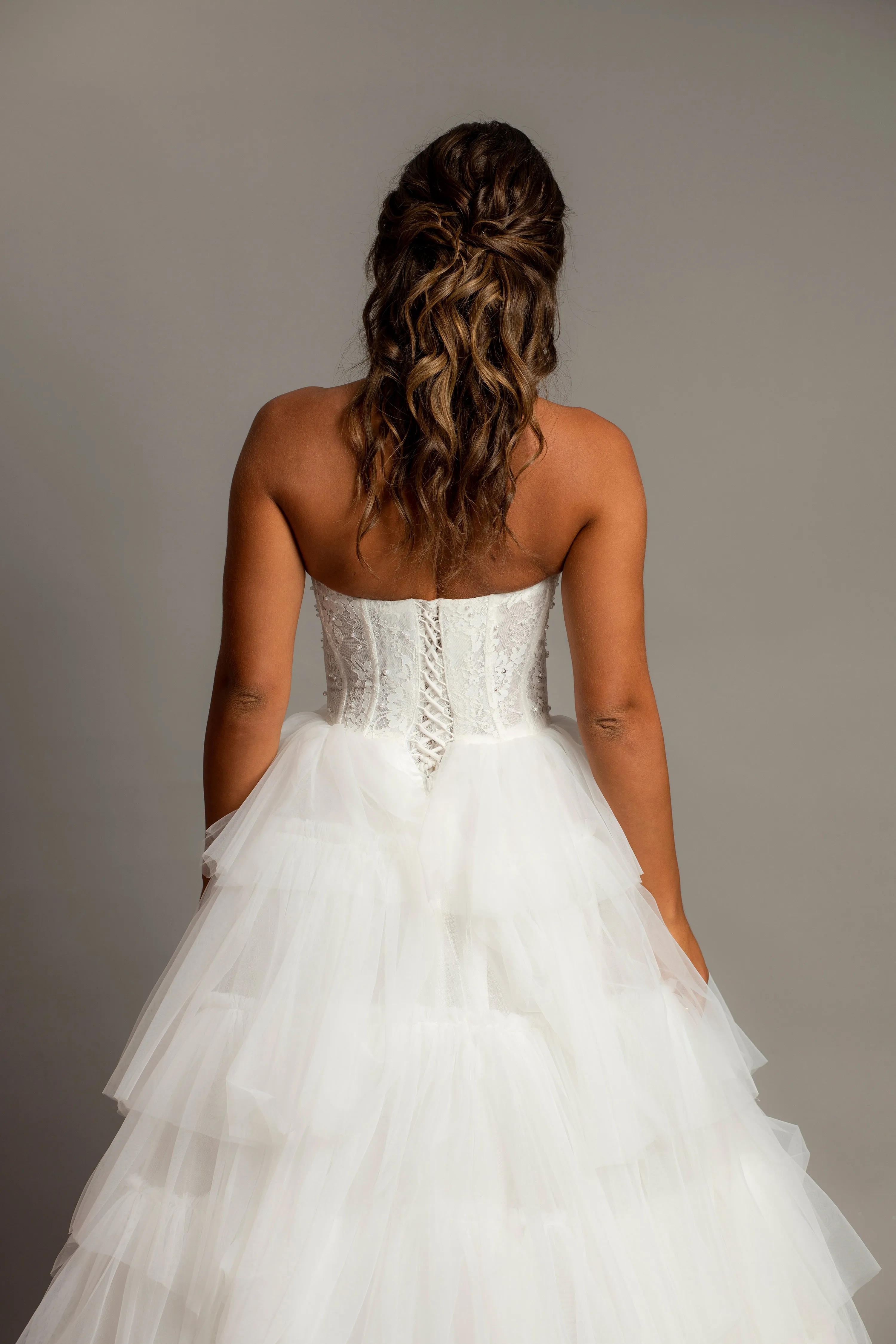 White wedding dress with a bushier top and a bushier puffy layered skirt